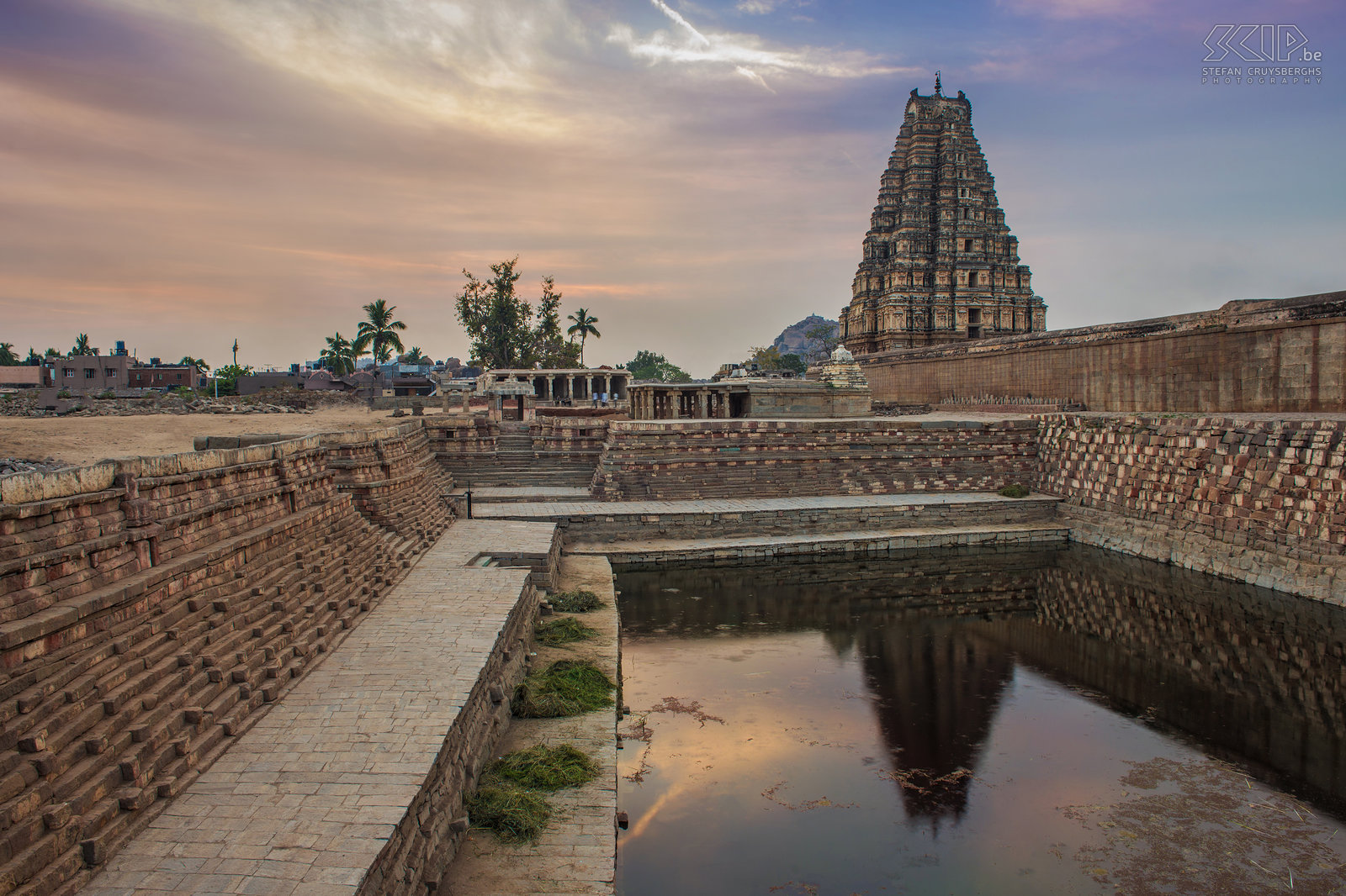 Hampi - Virupaksha tempel Zonsopgang aan de noordzijde van de Virupaksha tempel in Hampi. De prachtige oude stad van Hampi is gelegen in de deelstaat Karnataka in het zuiden van India. In de 13e tot de 17e eeuw was het de hoofdstad van het Vijayanagararijk, maar aangenomen wordt dat deze tempel gebouwd werd in de 7e eeuw na Chr. Deze indrukwekkende tempel is nog steeds een pelgrimsoord voor de aanbidders van Shiva. De oostelijke toren, genaamd Gopura, is 49m hoog en heeft 9 verdiepingen. Stefan Cruysberghs